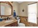 Charming bathroom featuring an ornate mirror, wood cabinets, and tile accents at 508 W San Angelo St, Gilbert, AZ 85233