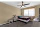Cozy bedroom featuring neutral walls, a ceiling fan, and a window letting in natural light at 508 W San Angelo St, Gilbert, AZ 85233
