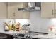 Close-up of kitchen counter with stainless steel range hood, decorative items and white backsplash at 508 W San Angelo St, Gilbert, AZ 85233