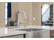 Kitchen island with a stainless steel sink and faucet beneath a window-lit staircase at 508 W San Angelo St, Gilbert, AZ 85233