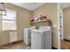 Functional laundry room with washer, dryer, and shelving for storage at 508 W San Angelo St, Gilbert, AZ 85233