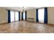Spacious open-concept living room area featuring neutral paint, travertine floors, and blue curtains at 508 W San Angelo St, Gilbert, AZ 85233