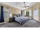 Cozy main bedroom with a king bed, ceiling fan, and natural light from large windows at 508 W San Angelo St, Gilbert, AZ 85233