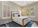 Bright bedroom showcasing a comfortable bed, shuttered windows offering natural light, and stylish decor atop a blue patterned rug at 5291 S Bradshaw Pl, Chandler, AZ 85249