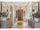 Elegant foyer featuring a decorative wood door, tiled flooring, statement lighting and side tables with artful details at 5291 S Bradshaw Pl, Chandler, AZ 85249