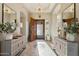 Inviting foyer featuring a decorative wood door with tiled flooring and side tables with plants and gold accents at 5291 S Bradshaw Pl, Chandler, AZ 85249