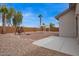 A desert landscaped backyard with a covered patio and swing set in the distance at 695 S 221St Dr, Buckeye, AZ 85326