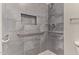 Tiled shower with safety bars, rainfall shower head, and soap nook at 695 S 221St Dr, Buckeye, AZ 85326