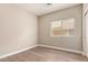 This bedroom features neutral walls, a window with blinds, and wood-look floors at 695 S 221St Dr, Buckeye, AZ 85326