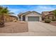 Charming home featuring a well-manicured front yard with gravel landscaping and a two-car garage at 695 S 221St Dr, Buckeye, AZ 85326