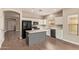A modern kitchen with a center island, stainless steel appliances, and wood laminate flooring at 695 S 221St Dr, Buckeye, AZ 85326
