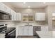 Bright kitchen features stainless steel appliances, white cabinets, and quartz countertops at 695 S 221St Dr, Buckeye, AZ 85326