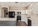Well-lit kitchen with a center island, stainless steel appliances, and white cabinetry at 695 S 221St Dr, Buckeye, AZ 85326