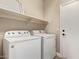This laundry room includes a Whirlpool washer/dryer set, white shelving, and neutral walls at 695 S 221St Dr, Buckeye, AZ 85326