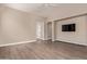 A spacious living room with wood laminate floors, neutral paint and a wall mounted television at 695 S 221St Dr, Buckeye, AZ 85326