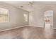 A spacious living room with wood laminate floors, neutral paint and a sliding door to the backyard at 695 S 221St Dr, Buckeye, AZ 85326