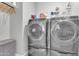Laundry room complete with modern washer and dryer, storage space, and shelving at 717 N Abalone Ct, Gilbert, AZ 85233