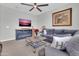 Cozy living room featuring a fireplace, TV, ceiling fan, and comfortable seating at 717 N Abalone Ct, Gilbert, AZ 85233