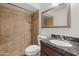 Bathroom featuring a shower, toilet, vanity with dark countertops, and a decorative mirror at 7337 E Ivyglen St, Mesa, AZ 85207