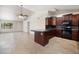 Kitchen featuring dark wood cabinets, granite countertops, and tile flooring at 7337 E Ivyglen St, Mesa, AZ 85207