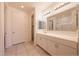 Bathroom featuring double sinks, large mirror, and tile flooring at 7648 W Kerby Ave, Phoenix, AZ 85043