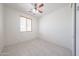 Cozy bedroom with tile flooring, natural light, and a ceiling fan at 7648 W Kerby Ave, Phoenix, AZ 85043