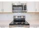 Close up of the kitchen with stainless steel microwave, oven and cook top at 7648 W Kerby Ave, Phoenix, AZ 85043
