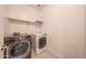 Laundry room featuring a newer washer and dryer set with overhead storage at 7648 W Kerby Ave, Phoenix, AZ 85043