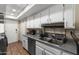 Functional kitchen area with stainless appliances, white cabinets, and a practical layout at 8653 S 51St St # 2, Phoenix, AZ 85044