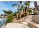 Landscaped backyard with decorative retaining wall, mature palm trees, and view of canal at 896 E Indian Wells Pl, Chandler, AZ 85249