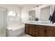 Bright bathroom featuring double vanities, marble countertops, and a glass-enclosed shower at 896 E Indian Wells Pl, Chandler, AZ 85249