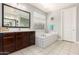 Bathroom featuring double vanity, a separate tub, and a large mirror at 913 W Yosemite Dr, Chandler, AZ 85248