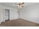 Comfortable bedroom with neutral carpeting, a ceiling fan, and ample closet space for storage at 9265 N 111Th Ave, Sun City, AZ 85351