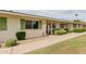Exterior view of a home with lush green shrubbery and a sidewalk leading to the entrance at 9265 N 111Th Ave, Sun City, AZ 85351