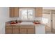 Bright and tidy kitchen featuring light wood cabinets and neutral countertops, complemented by a window view at 9265 N 111Th Ave, Sun City, AZ 85351