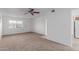 Bright and airy living area with neutral carpet, ceiling fan, and a large window at 9265 N 111Th Ave, Sun City, AZ 85351