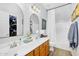 Well-lit bathroom featuring double sinks, a tub with shower, and neutral decor at 948 E Savannah Dr, Chandler, AZ 85225