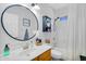 Clean bathroom with a large round mirror and combined tub and shower with white tile surround at 948 E Savannah Dr, Chandler, AZ 85225