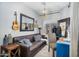 Bright living room with leather sofa, modern light fixture, large mirror, and blue desk at 948 E Savannah Dr, Chandler, AZ 85225