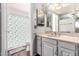 Bathroom featuring a double sink vanity, mirror, and shower with a fun duck-themed curtain at 10032 N 50Th Dr, Glendale, AZ 85302