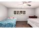 Cozy bedroom with two beds, ceiling fan, shuttered window, and wood-look flooring at 10032 N 50Th Dr, Glendale, AZ 85302