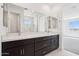 Bright bathroom featuring a double vanity, large mirror, and window at 10253 E Ursula Ave, Mesa, AZ 85212