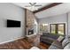 Living room features a fireplace, wood floors, large windows, and exposed beams at 11131 E Becker Ln, Scottsdale, AZ 85259