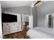 Spacious bedroom with wood floors, a large dresser, and an open doorway to the living area at 11131 E Becker Ln, Scottsdale, AZ 85259