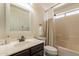 Cozy bathroom featuring a shower-tub combo, dark wood vanity, and decorative mirror at 1125 S Larkspur St, Gilbert, AZ 85296