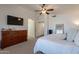 Spacious bedroom featuring bed, dresser, television, and entryway to the bathroom at 1125 S Larkspur St, Gilbert, AZ 85296