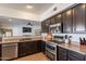 Open kitchen with stainless steel appliances, dark wood cabinetry, and a breakfast bar at 1125 S Larkspur St, Gilbert, AZ 85296