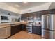 Fully-equipped kitchen features stainless steel appliances, dark wood cabinets, and a breakfast bar at 1125 S Larkspur St, Gilbert, AZ 85296