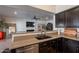 Spacious kitchen featuring a breakfast bar, stainless steel dishwasher, and ample counter space at 1125 S Larkspur St, Gilbert, AZ 85296