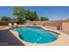 Backyard swimming pool is surrounded by trees, lounge chairs, and block wall at 1125 S Larkspur St, Gilbert, AZ 85296